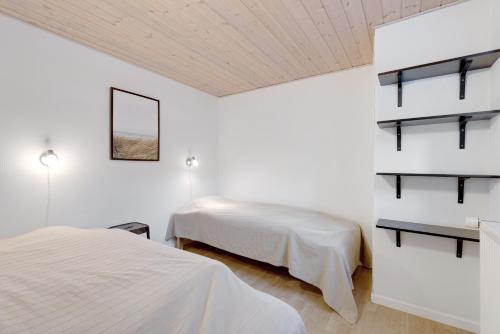 two beds in a room with white walls at Adventure Park Apartments in Ringkøbing