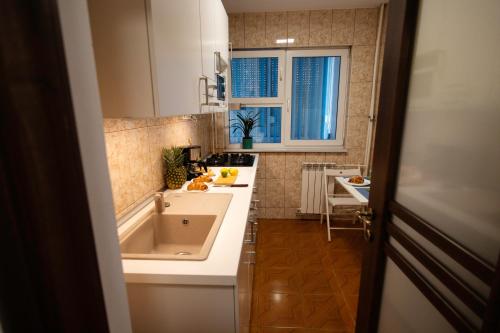 une petite cuisine avec un évier et une baignoire dans l'établissement White Glamour, à Buzău