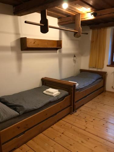 2 Einzelbetten in einem Zimmer mit Holzböden in der Unterkunft Chata U Janka in Bělá pod Pradědem