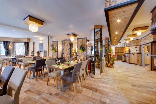 een restaurant met houten vloeren en tafels en stoelen bij La Galise in Val dʼIsère