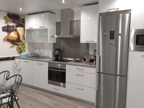 a kitchen with white cabinets and a stainless steel refrigerator at VIVE CENTRO ASTORGA in Astorga