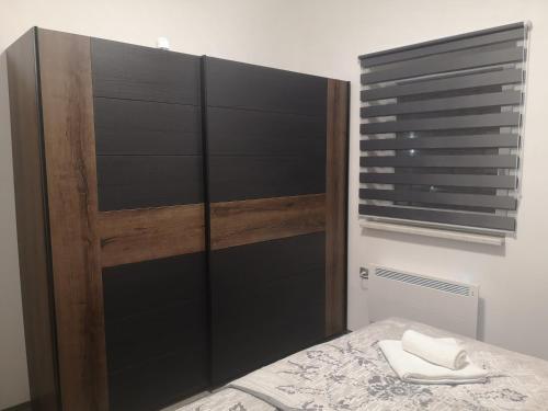 a bedroom with a bed with a wooden headboard at APP Vanja 6170 in Čatež ob Savi