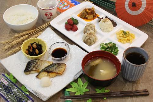 a table with two plates of food and two dipping sauces at Henn na Hotel Premier Tokyo Asakusa Tawaramachi in Tokyo