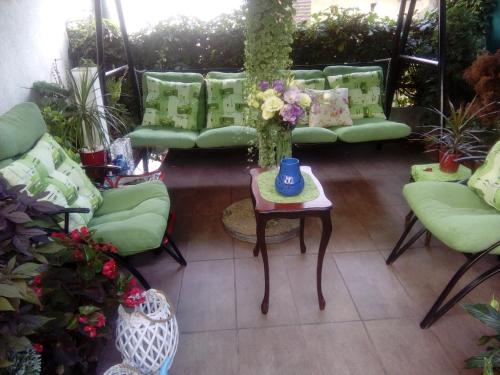 a room with green couches and a table with a vase at Apartments Skadarlija in Belgrade