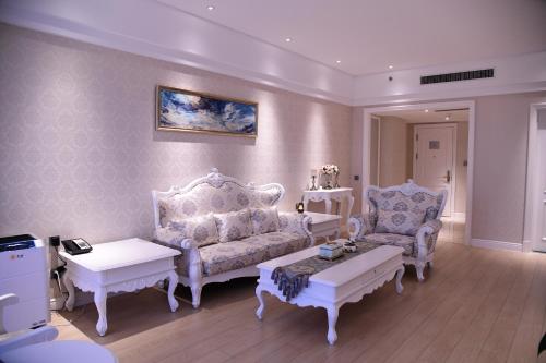 a living room with two chairs and a couch at GUOCE Beijing Capital Airport Hotel & Convention Center in Shunyi