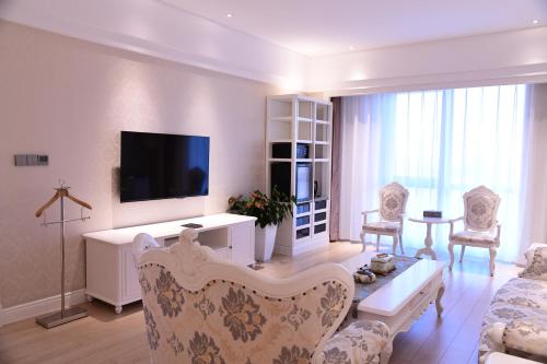 a living room with a couch and a tv at GUOCE Beijing Capital Airport Hotel & Convention Center in Shunyi