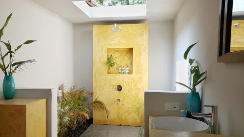 Un baño con una puerta amarilla y un lavabo. en Marari Villas - Private Pool Villas, en Mararikulam
