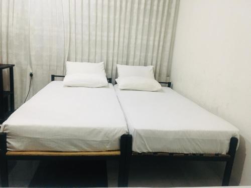uma cama com duas almofadas num quarto em View City Point em Kandy