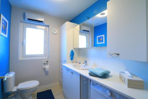 Baño azul con aseo y lavamanos en Appartement de 57m2 vue sur mer et plage, en Le Portel