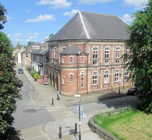 a large red brick building with a grey roof at Victoria Bar Apartments Within the City Walls Free Parking in York
