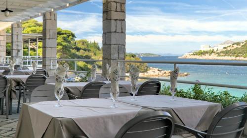 a restaurant with tables and chairs with a view of the ocean at Hotel Vis in Dubrovnik