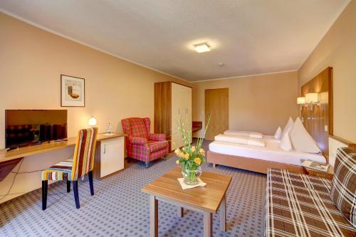 ObernzellにあるZum Edlhofのベッドとテーブルが備わるホテルルームです。