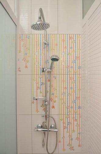 a shower with colorful streamers on the wall in a bathroom at Residence Coin De Mire in Bain Boeuf