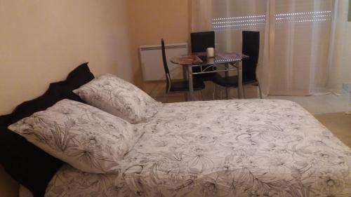 - un lit blanc dans une chambre avec une table dans l'établissement STUDIO 3mn A PIED DE LA PLAGE AVEC TERRASSE, à Antibes