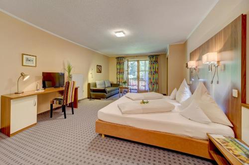 a hotel room with a large bed and a desk at Zum Edlhof in Obernzell