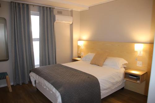 a hotel room with a bed and a window at The Boardwalk Accommodation in Gordonʼs Bay
