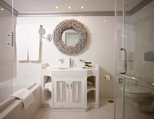 Mitsis Selection Alila في فاليراكي: حمام مع حوض ومرآة على الحائط