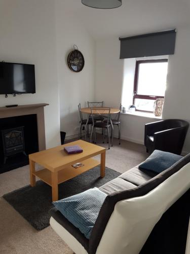 a living room with a couch and a table at Penbryn Holidays, Barmouth in Barmouth