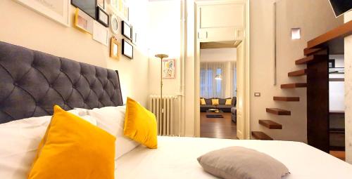 1 dormitorio con 1 cama con almohadas amarillas en Heart Milan Apartments Duomo Castello, en Milán
