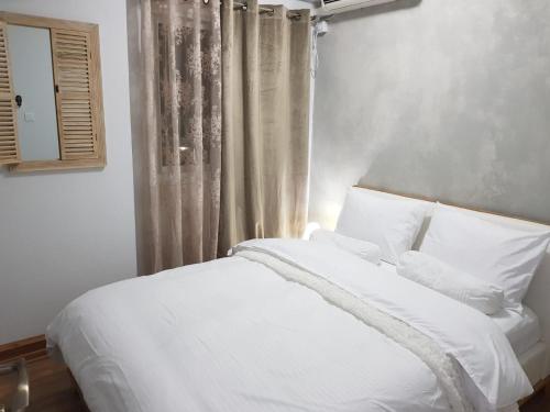 a white bed with white pillows and a window at See&Sun in Ashdod