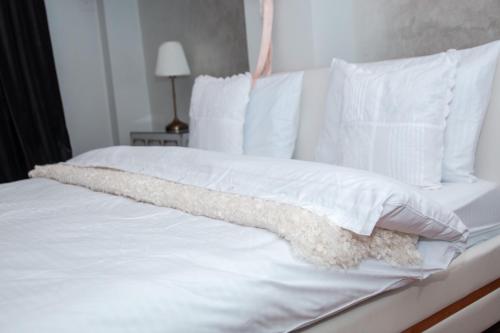 a white bed with white sheets and pillows at See&Sun in Ashdod