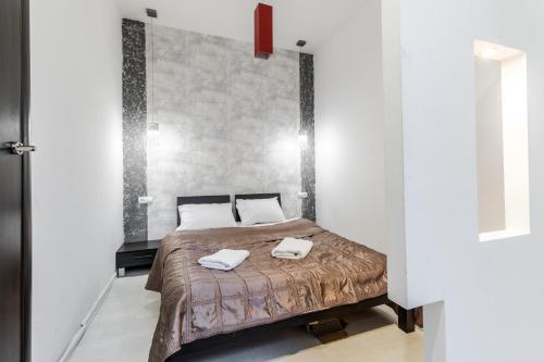 une chambre avec un lit avec deux serviettes dessus dans l'établissement Black and Red squares apartment, à Lviv