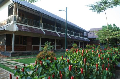 a building with red flowers in front of it at GREEN PLANET HOTEL in Mattanūr