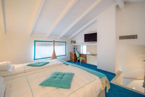 um quarto com uma grande cama branca com almofadas verdes em Piccolo Grand Hotel em Pizzo