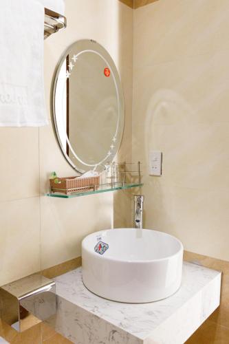 a bathroom with a white sink and a mirror at Moschino HT in Nha Trang