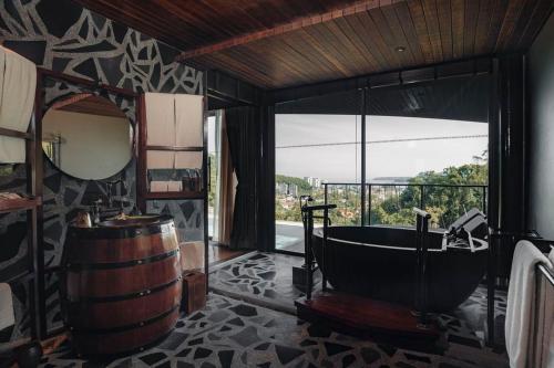 a bathroom with a tub and a mirror and a barrel at Keemala in Kamala Beach