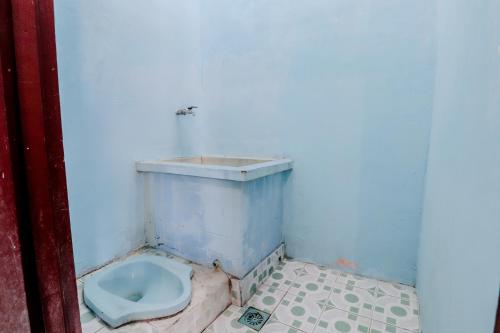 a bathroom with a blue toilet in the corner at Losmen Parikesit in Bantul