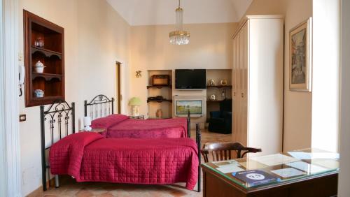 1 dormitorio con 2 camas y mantas rojas en B&B S. Teresa, en Altamura