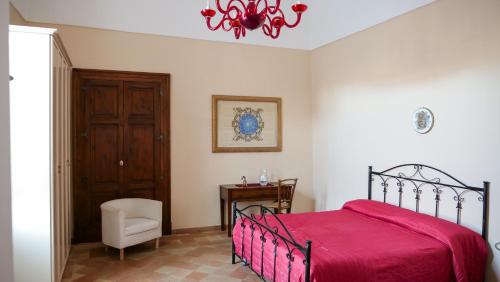 a bedroom with a bed and a chair and a chandelier at B&B S. Teresa in Altamura