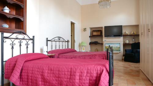 a bedroom with two beds with pink blankets at B&B S. Teresa in Altamura