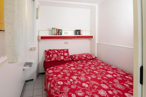 um pequeno quarto com uma cama vermelha num quarto em Camping Village Miramare em Cavallino-Treporti