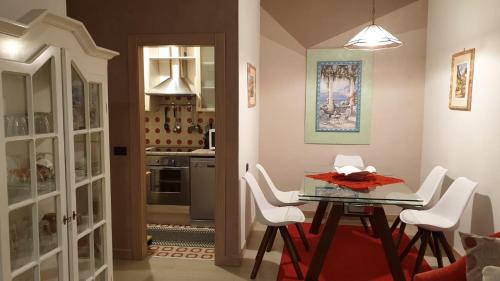 uma sala de jantar com uma mesa de vidro e cadeiras brancas em Mont&Lac em Limone sul Garda