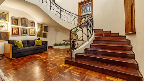 a living room with a staircase and a couch at Christies at 32 on Russell in Nelspruit