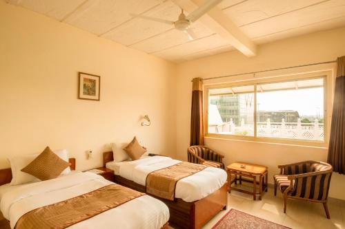 a hotel room with two beds and a window at Airport Hotel in New Delhi