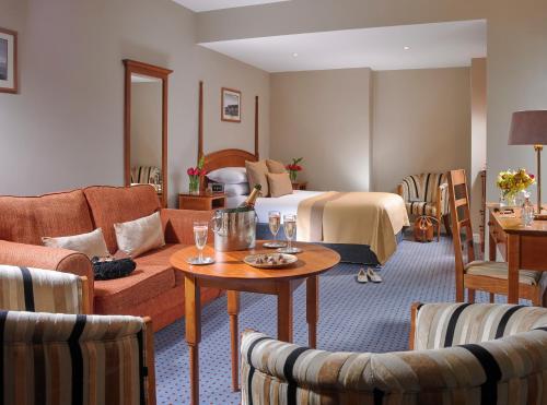 a hotel room with a bed and a table and chairs at The Parkavon Hotel in Killarney