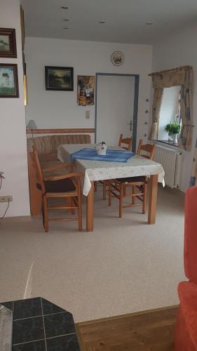 uma sala de estar com mesa e cadeiras em Ferienwohnung am Sandwater em Ihlow