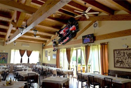 a dining room with tables and a ceiling fan at Locanda del Lupo in Faenza