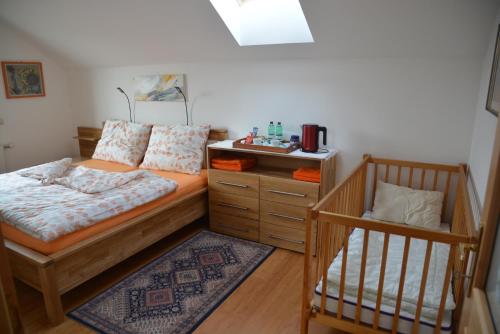 ein Schlafzimmer mit einem Bett und einem Kinderbett in der Unterkunft Privatzimmer Marina in Völkermarkt