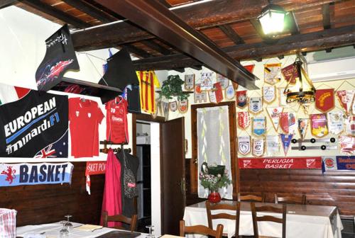 a restaurant with tables and signs on the wall at Locanda del Lupo in Faenza