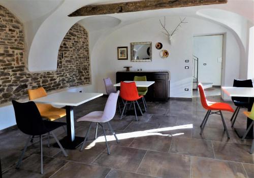 une chambre avec des tables, des chaises et une cheminée dans l'établissement Cascina Malinverni, à Rocchetta Palafea
