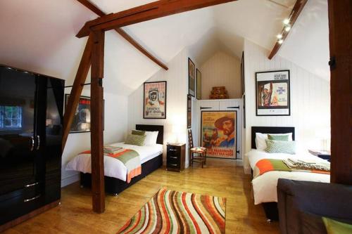 1 dormitorio con 2 camas y TV. en Old Croft Stables en Quarndon
