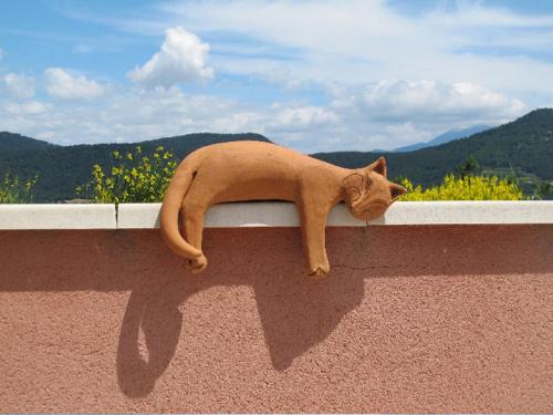 a cat laying on the ledge of a wall at Hotel Bellerive in Rasteau