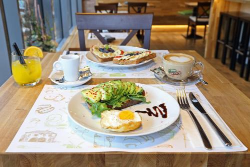 a table with two plates of food and cups of coffee at Apartmány Terasy Café in Liberec