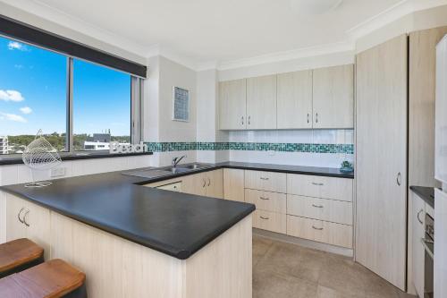 a kitchen with a sink and a large window at Elouera Tower in Maroochydore