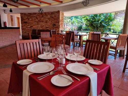 a table with a red table cloth and wine glasses at Nile Village Hotel & Spa in Jinja