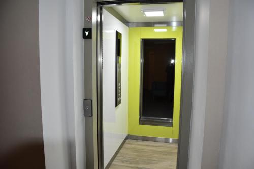a hallway with a mirror and a yellow wall at Landhotel Anna in Sankt Martin am Tennengebirge